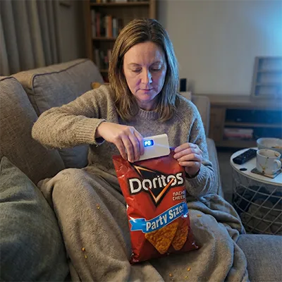Frau benutzt SnapSeal Mini Sealer an einer Chipstüte