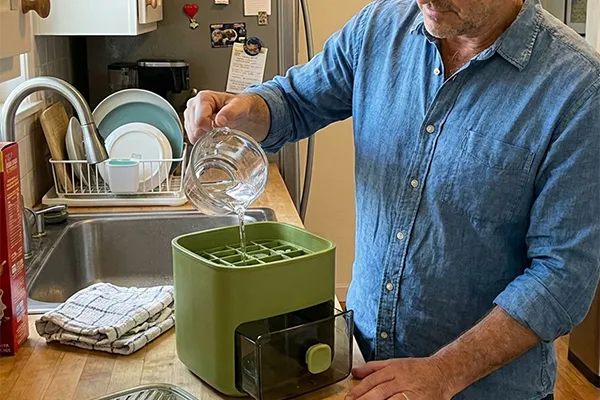 Mann benutzt die CubeNest für ein Getränk in der Küche