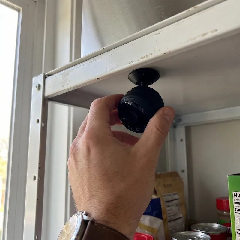 Mann bringt die iPuck magnetisch an einem Schrank an
