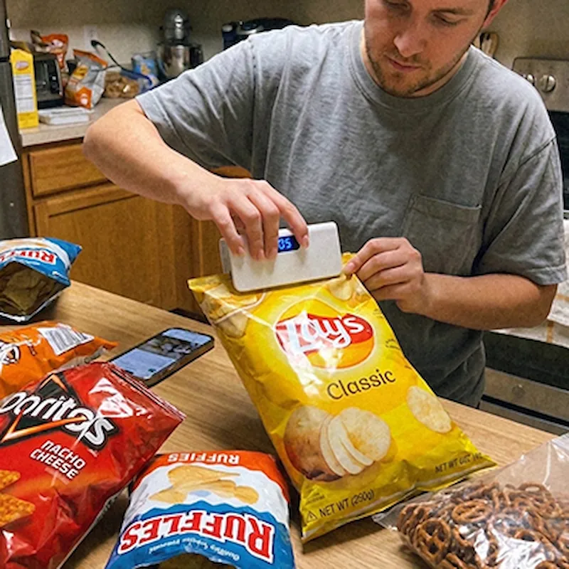 Familie in Küche die Essen frisch hält mit SnapSeal Mini Sealer